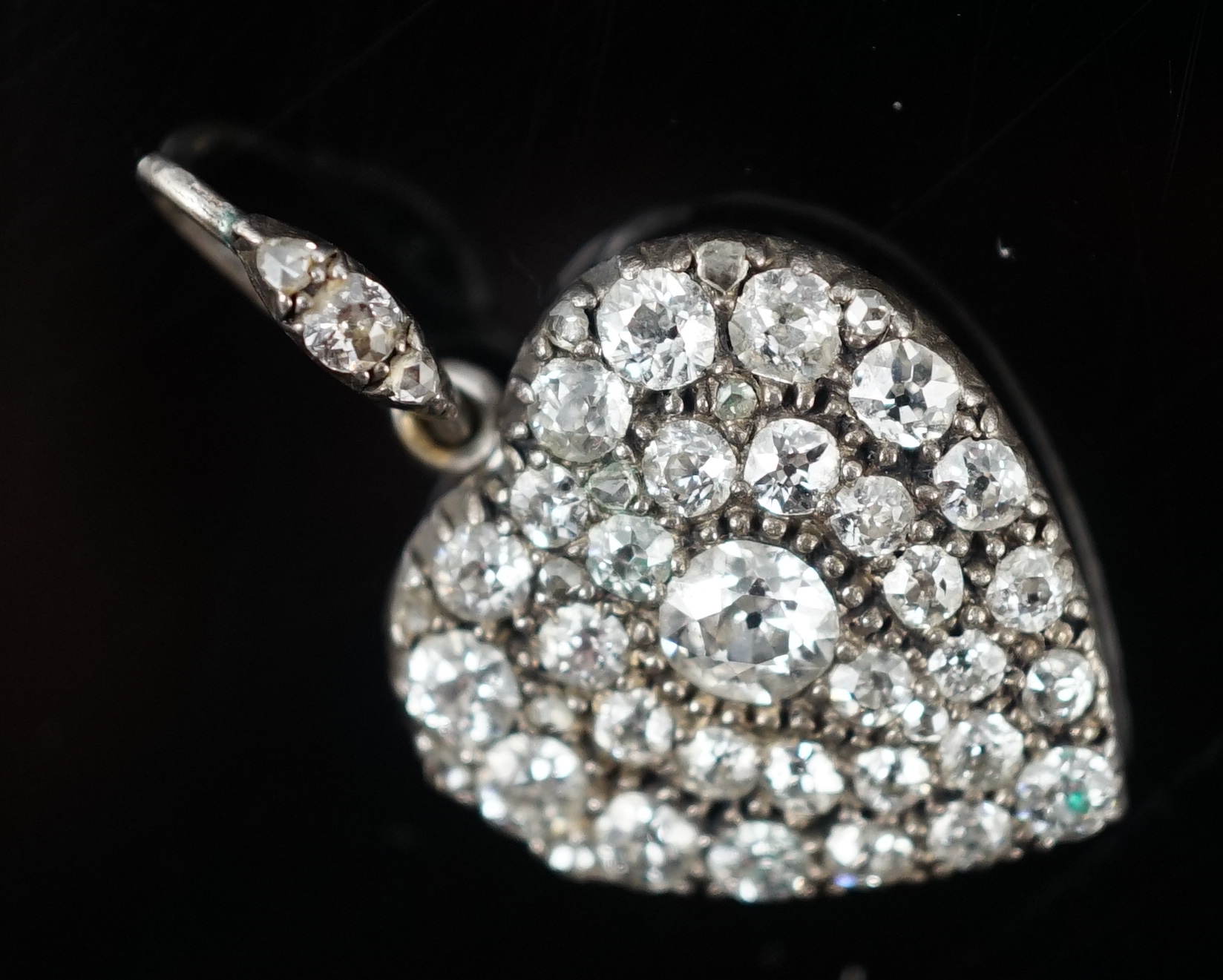 An early 20th century white gold and pave set diamond heart shaped pendant